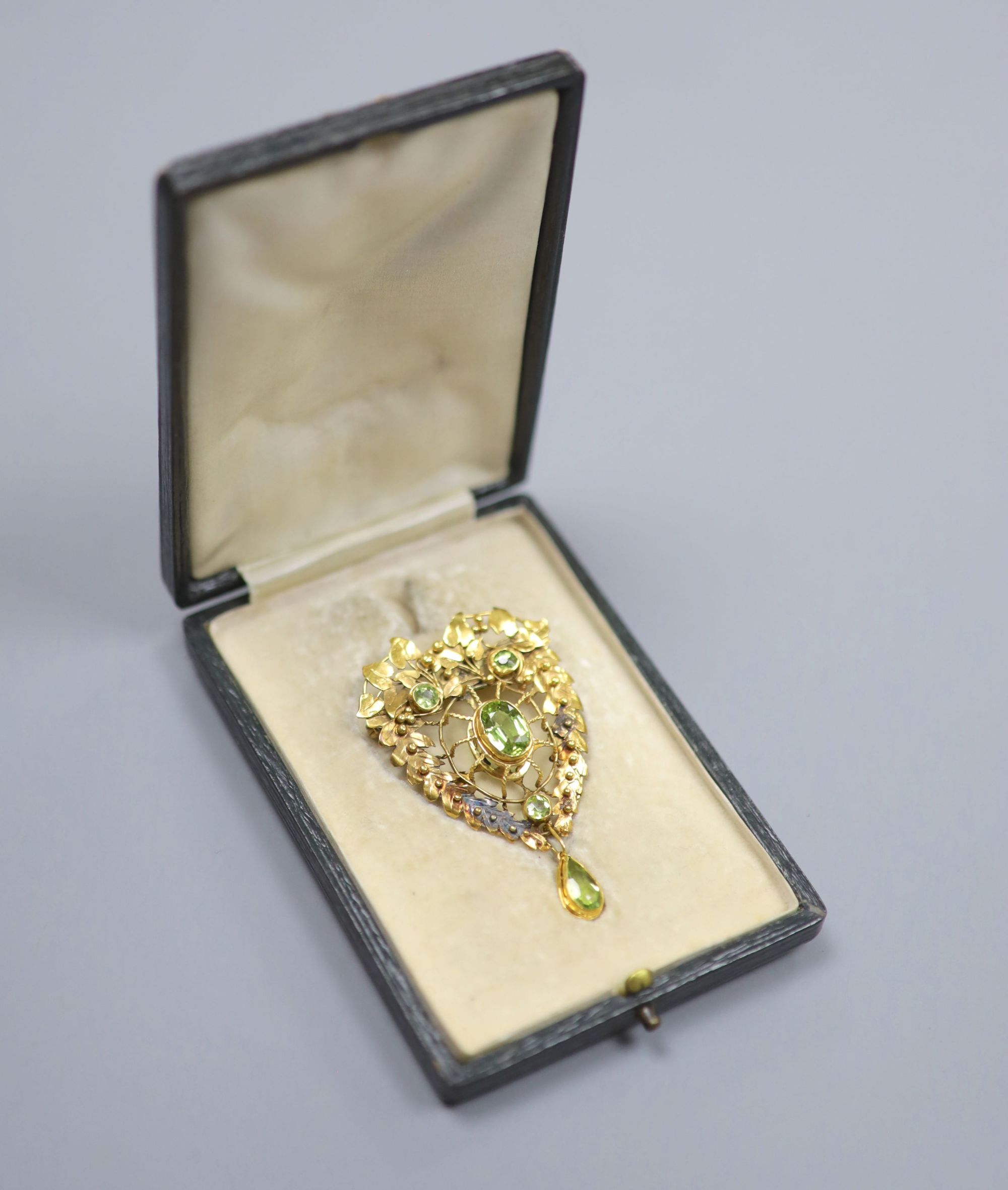 A pierced yellow metal and four stone peridot set brooch(adapted), 52mm, gross 9.7 grams.